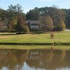 A green surrounded by water at Honey Creek Golf & Country Club with the clubhouse in background