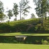 A view of the 12th green surrounded by water at Country Land Golf Course
