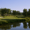 A view of green surrounded by water with clubhouse in background at Achasta Golf Club