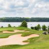 A view of elegant bunkers protecting a hole with the Cole Reservoir in backgound at Heron Bay Golf & Country Club.